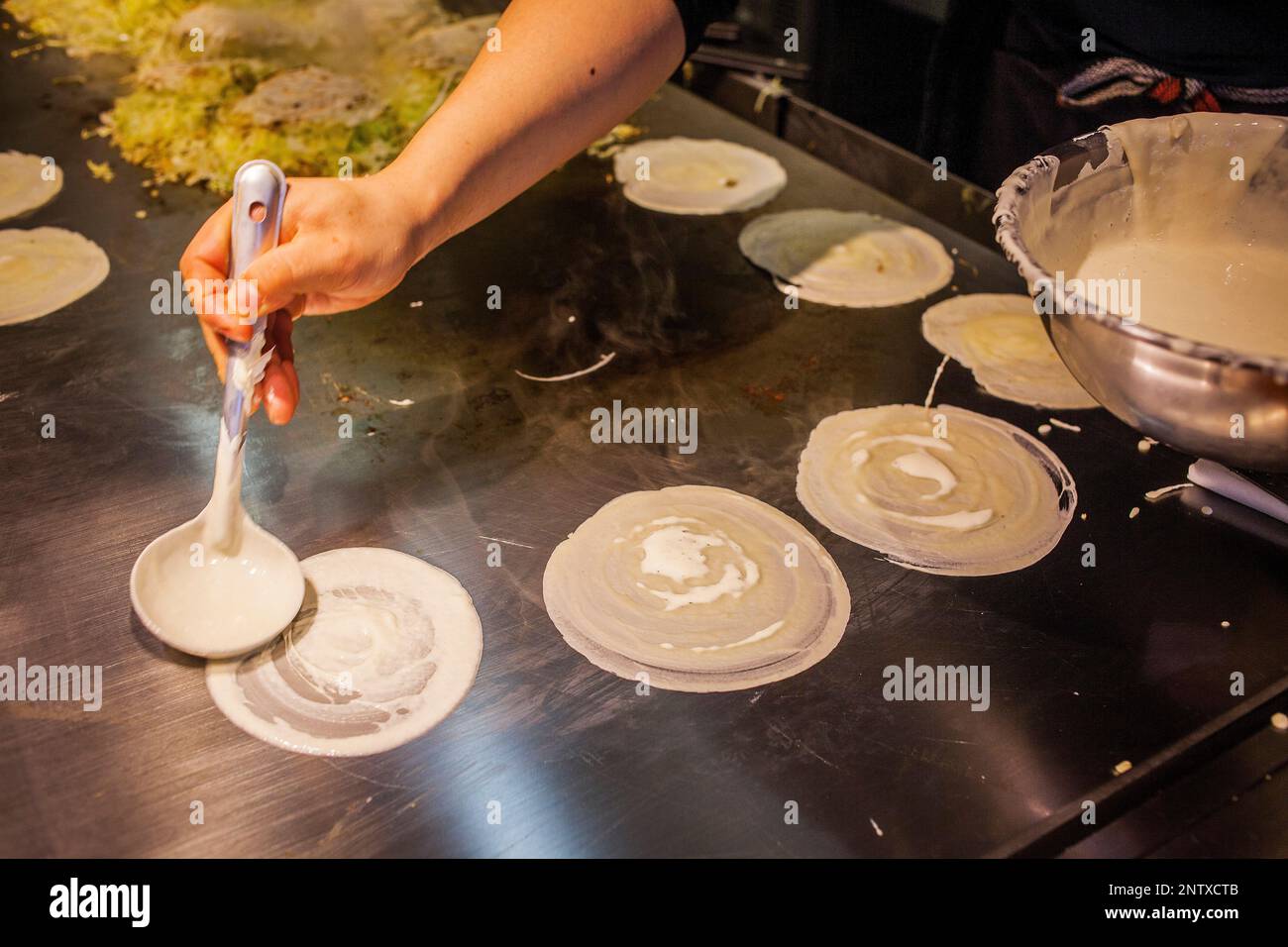 Okonomiyaki, chef au restaurant de l'okonomi-mura, Hiroshima, Japon Banque D'Images