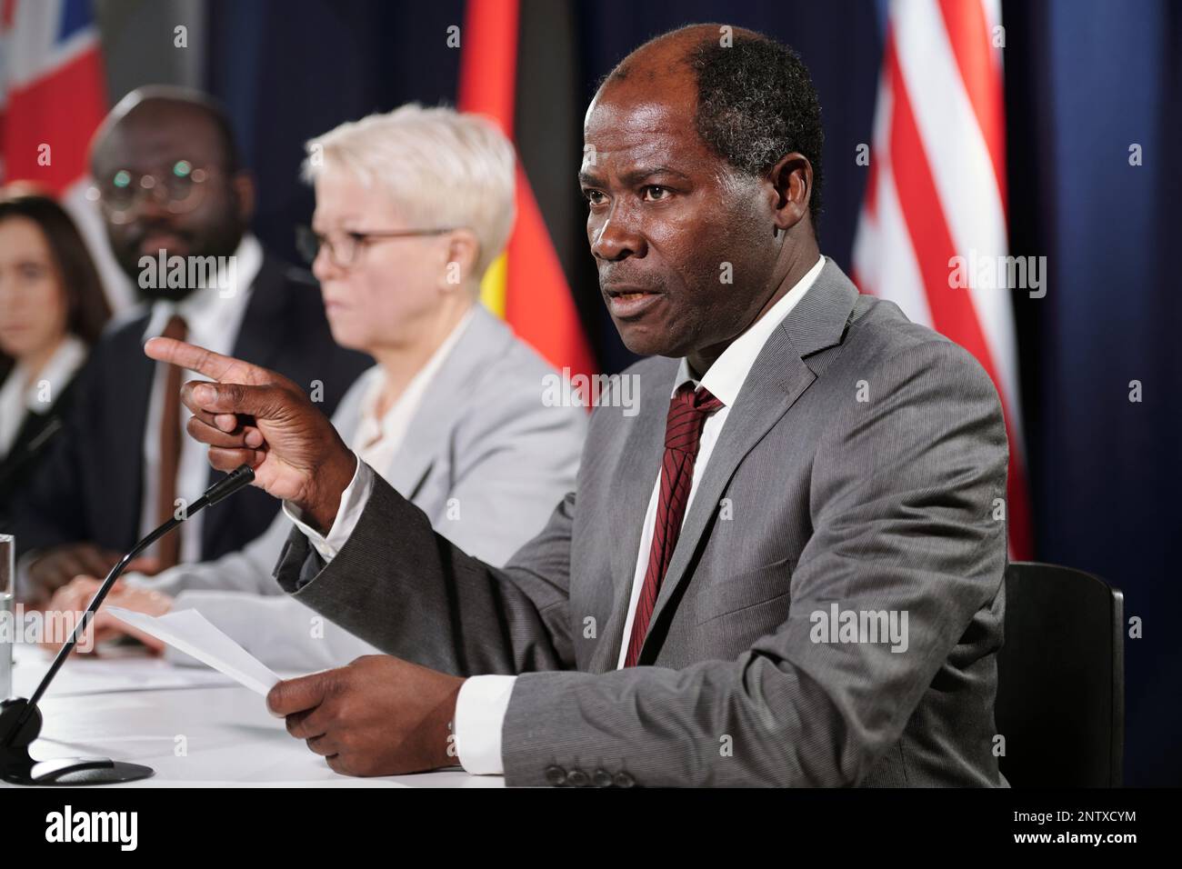 Un délégué afro-américain mature et confiant en tenue de cérémonie prononçant un discours politique à la conférence pour les pays inclus en G7 Banque D'Images