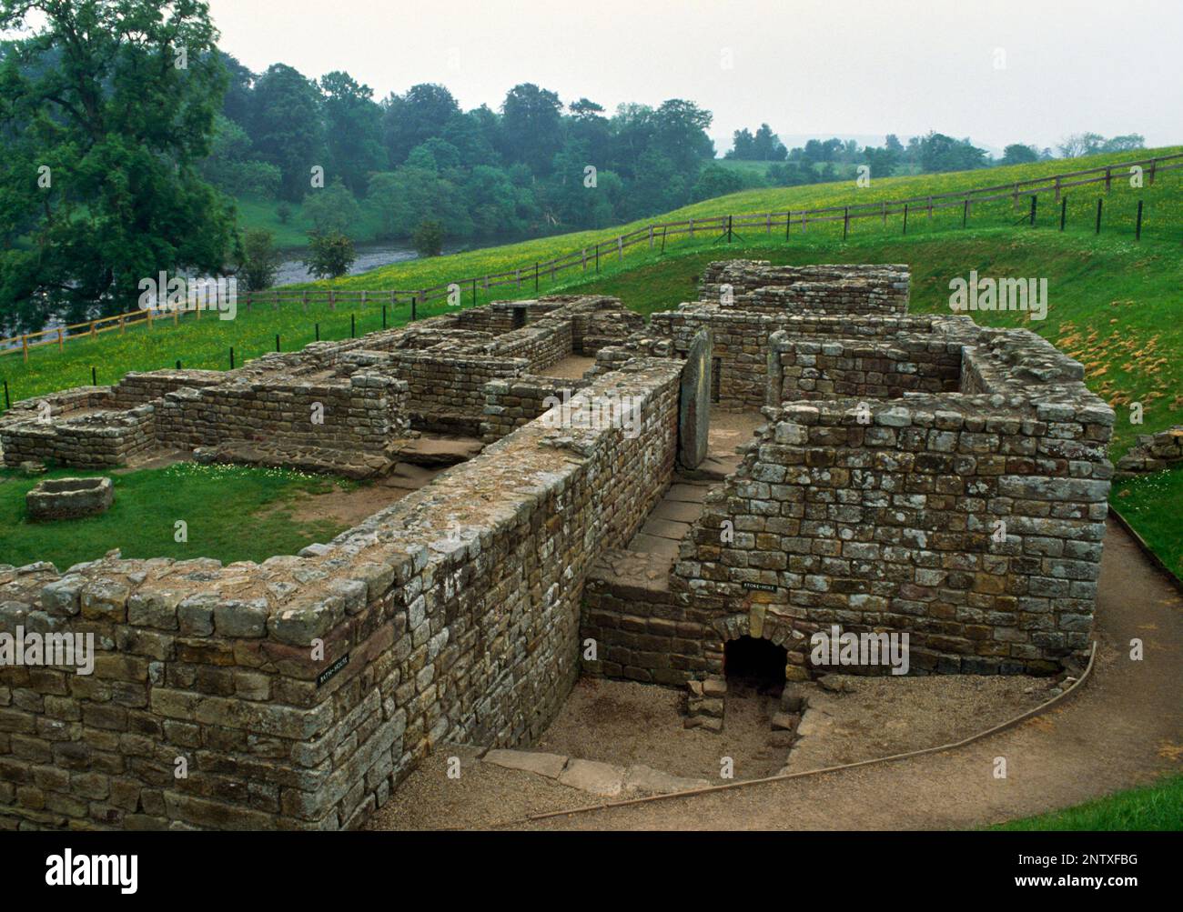 Maison romaine de bain à l'extérieur du mur E du fort romain de Chesters, mur d'Hadrien, Northumberland, Angleterre, Royaume-Uni, Vue S avec rivière North Tyne à L (E). Banque D'Images