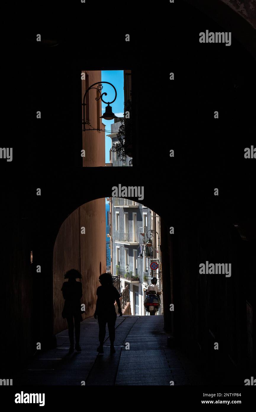 Deux personnes s'enordonnant sur une allée sombre du centro storico de Cagliari Banque D'Images