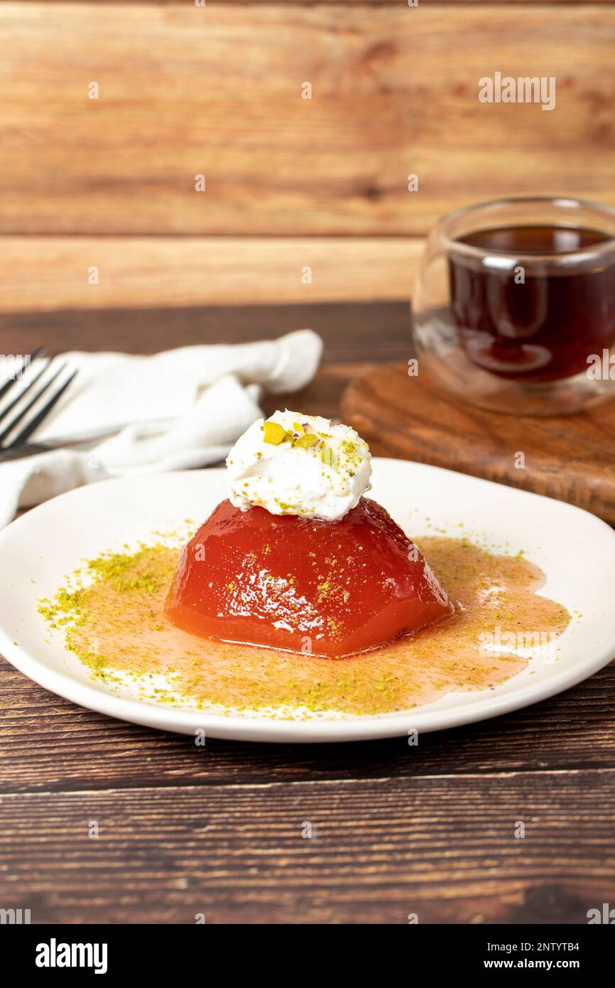 Dessert de coing avec sorbet sur fond gris. Dessert crémeux de coing. Spécialités sucrées du ramadan turc Banque D'Images