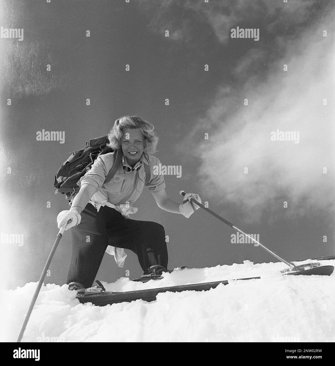 Dans les montagnes enneigées 1940s. Olga Sjögren de Stockholm est habillée dans la mode typique des sports d'hiver 1940s lors de l'escalade de la montagne enneigée Kuoblatjåkko à Norrbotten en Suède. La dernière des sept montagnes qu'elle a grimpé pour recevoir le prix: Les sept pics. Elle a passé 60 heures et a grimpé de 6558 mètres au total après avoir terminé. Suède 1943 Kristoffersson réf. H137-4 Banque D'Images