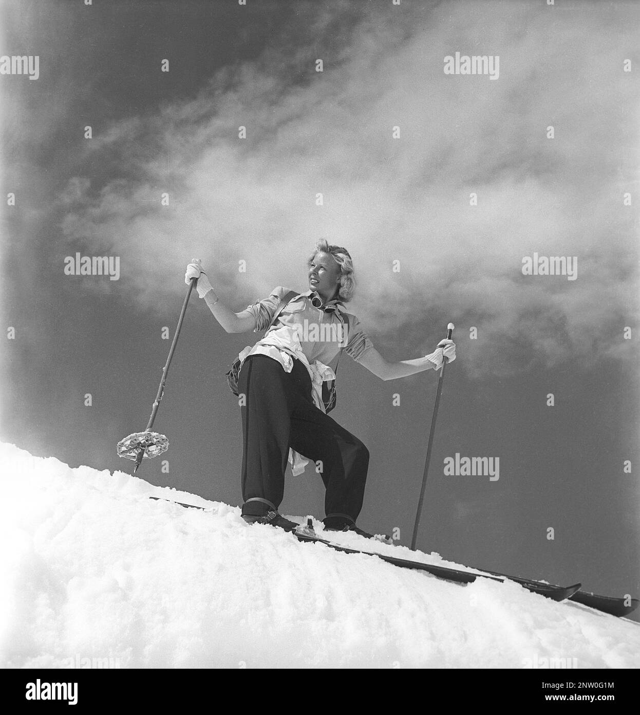 Dans les montagnes enneigées 1940s. Olga Sjögren de Stockholm est habillée dans la mode typique des sports d'hiver 1940s lors de l'escalade de la montagne enneigée Kuoblatjåkko à Norrbotten en Suède. La dernière des sept montagnes qu'elle a grimpé pour recevoir le prix: Les sept pics. Elle a passé 60 heures et a grimpé de 6558 mètres au total après avoir terminé. Suède 1943 Kristoffersson réf. H137-6 Banque D'Images