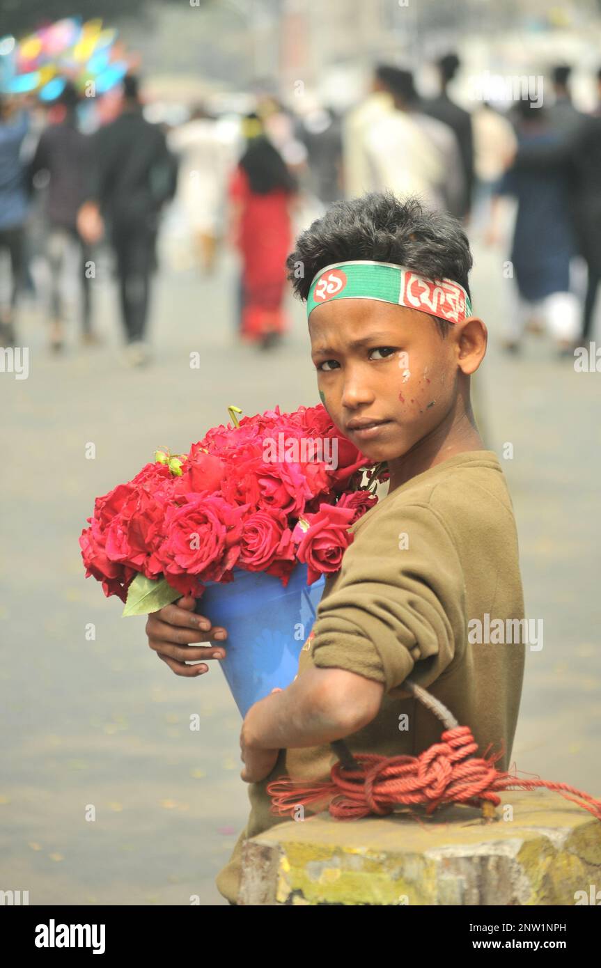 Dhaka, Bangladesh - 21 février 2023 : photo d'un enfant vendeur de fleurs dans une rue de la ville de Dhaka, au Bangladesh. Banque D'Images