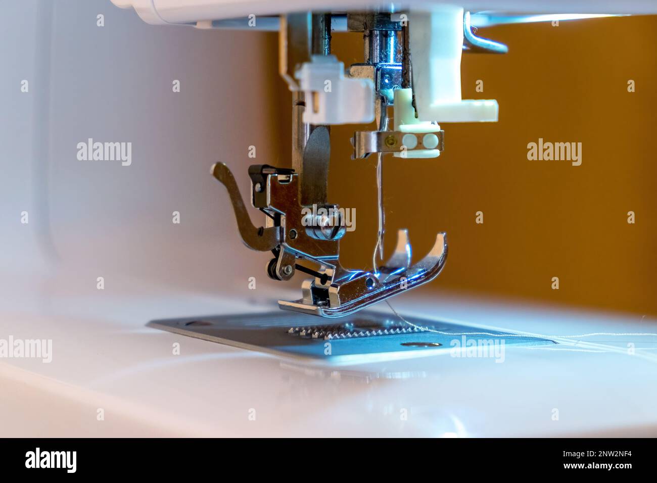 Partie de la machine à coudre. Gros plan de l'aiguille et du pied à coudre. Production de couture Banque D'Images