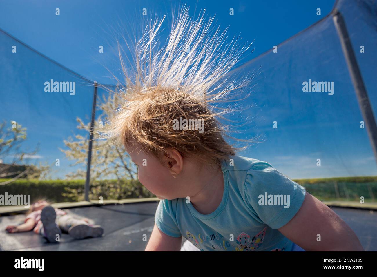 Des cheveux électrifiés de fille qui sautent sur un trampoline. Banque D'Images