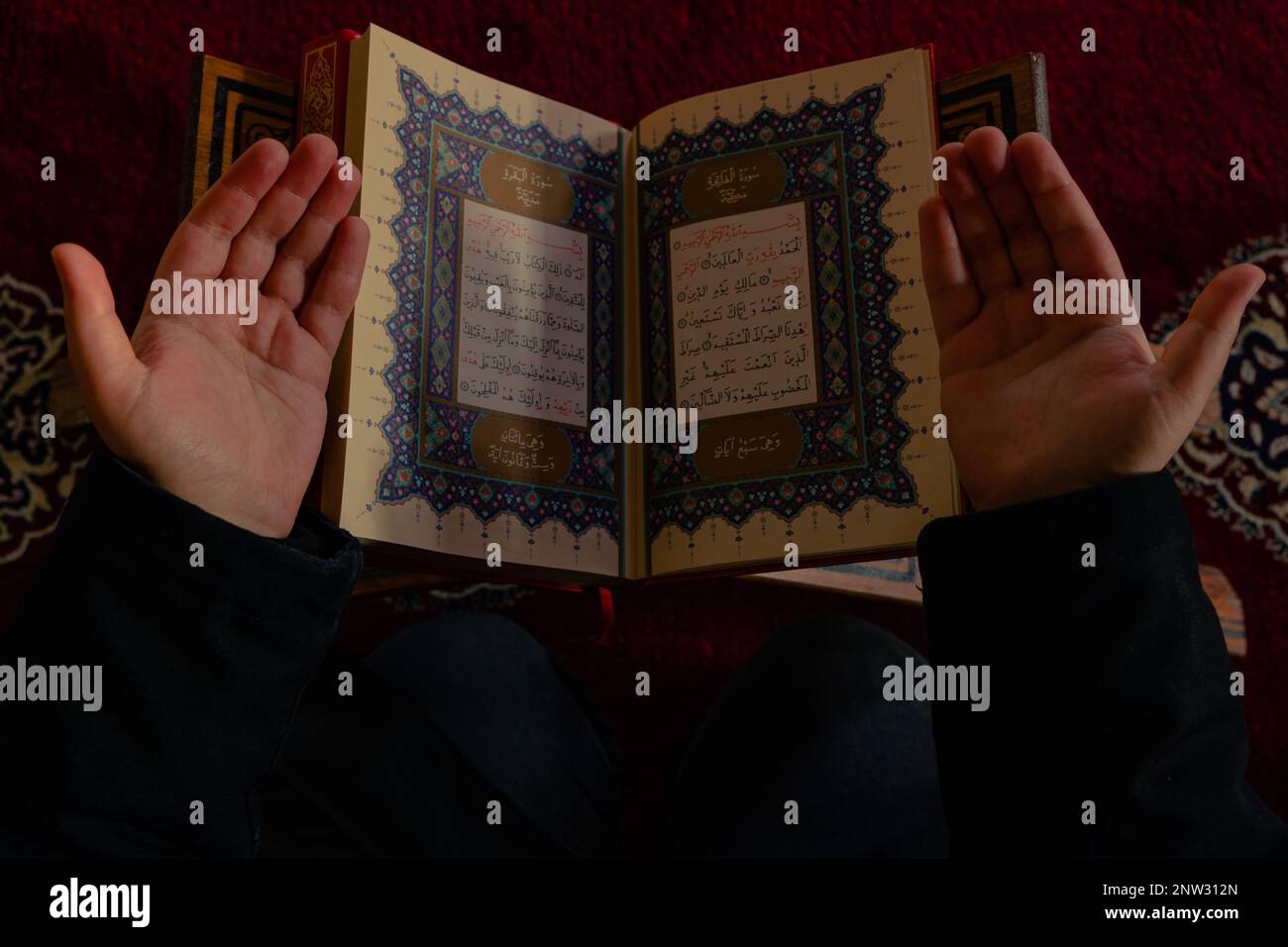 Photo islamique ou Ramadan. Prier avec les mains et le Saint Coran dans une mosquée. Homme musulman priant avec le Saint Coran. Istanbul Turkiye - 1.18.2023 Banque D'Images