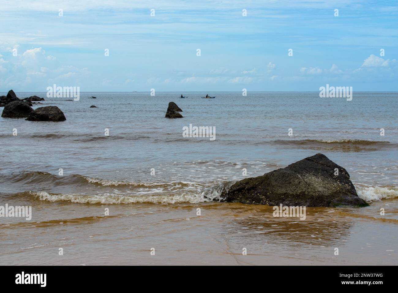 La photo capture une vue à couper le souffle d'une plage sereine avec des eaux cristallines et de douces vagues qui se délitent sur le rivage. Banque D'Images
