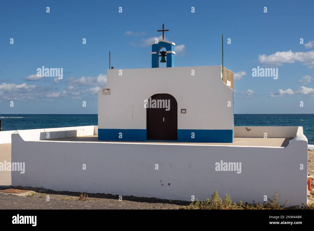 Petite église sur la côte est de l'océan Atlantique nommée Ermita de la Virgen del Pino. Combinaison simple de blanc et de bleu. Beffroi et une croix. PUE Banque D'Images