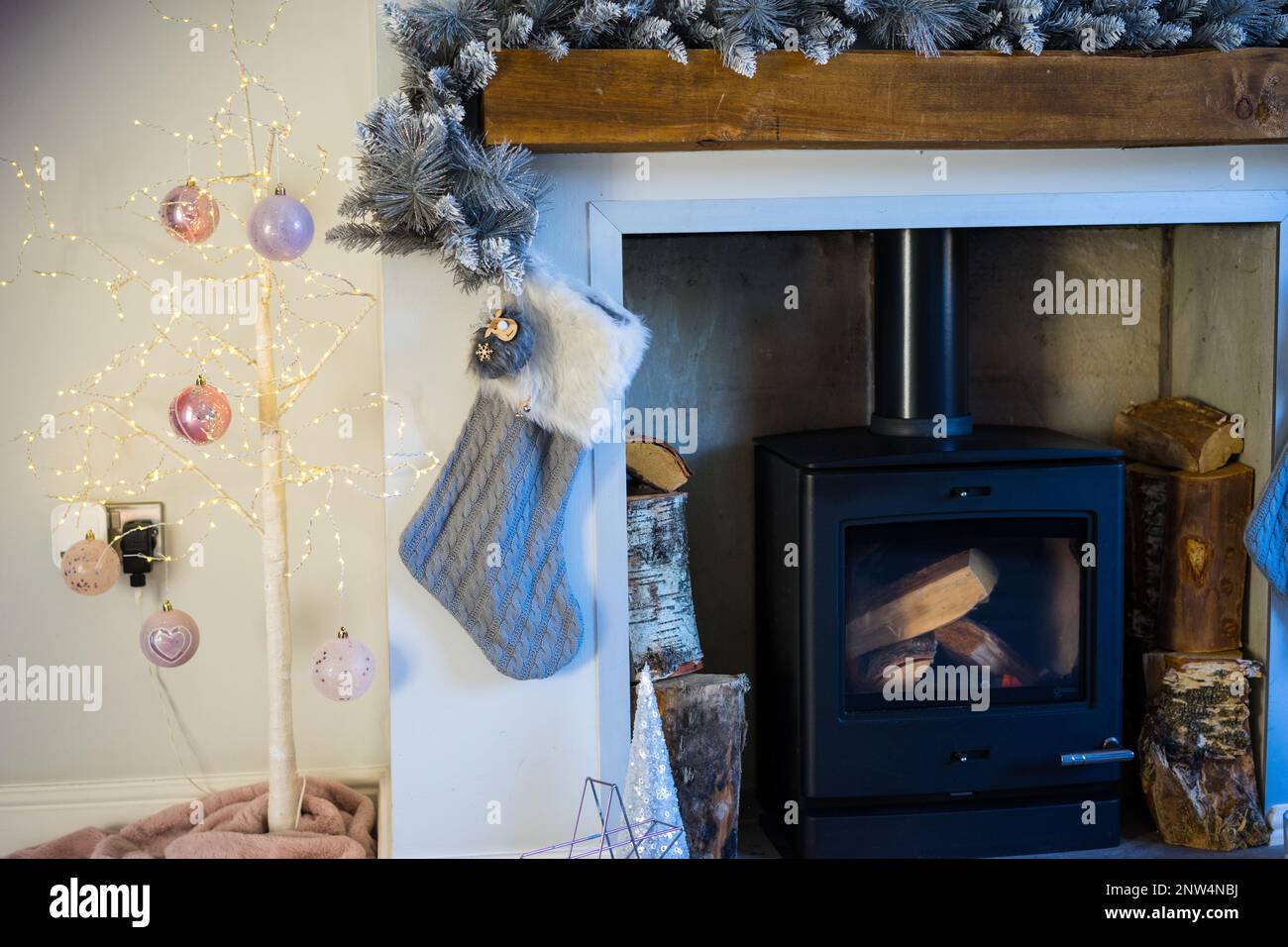 Les décorations de Noël entourent un brûleur à bois, Royaume-Uni. Banque D'Images