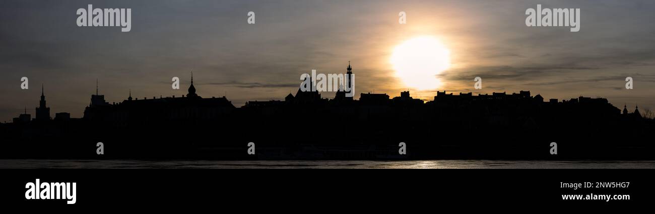 Vue panoramique sur la vieille ville de Varsovie sous le soleil couchant. Contours des bâtiments contre le ciel avec couleurs vives Banque D'Images