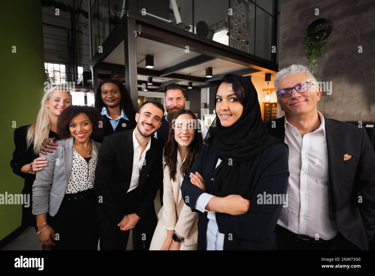 Portrait d'un grand groupe de travail avec une origine ethnique et un âge divers regardant la caméra sourire. Banque D'Images