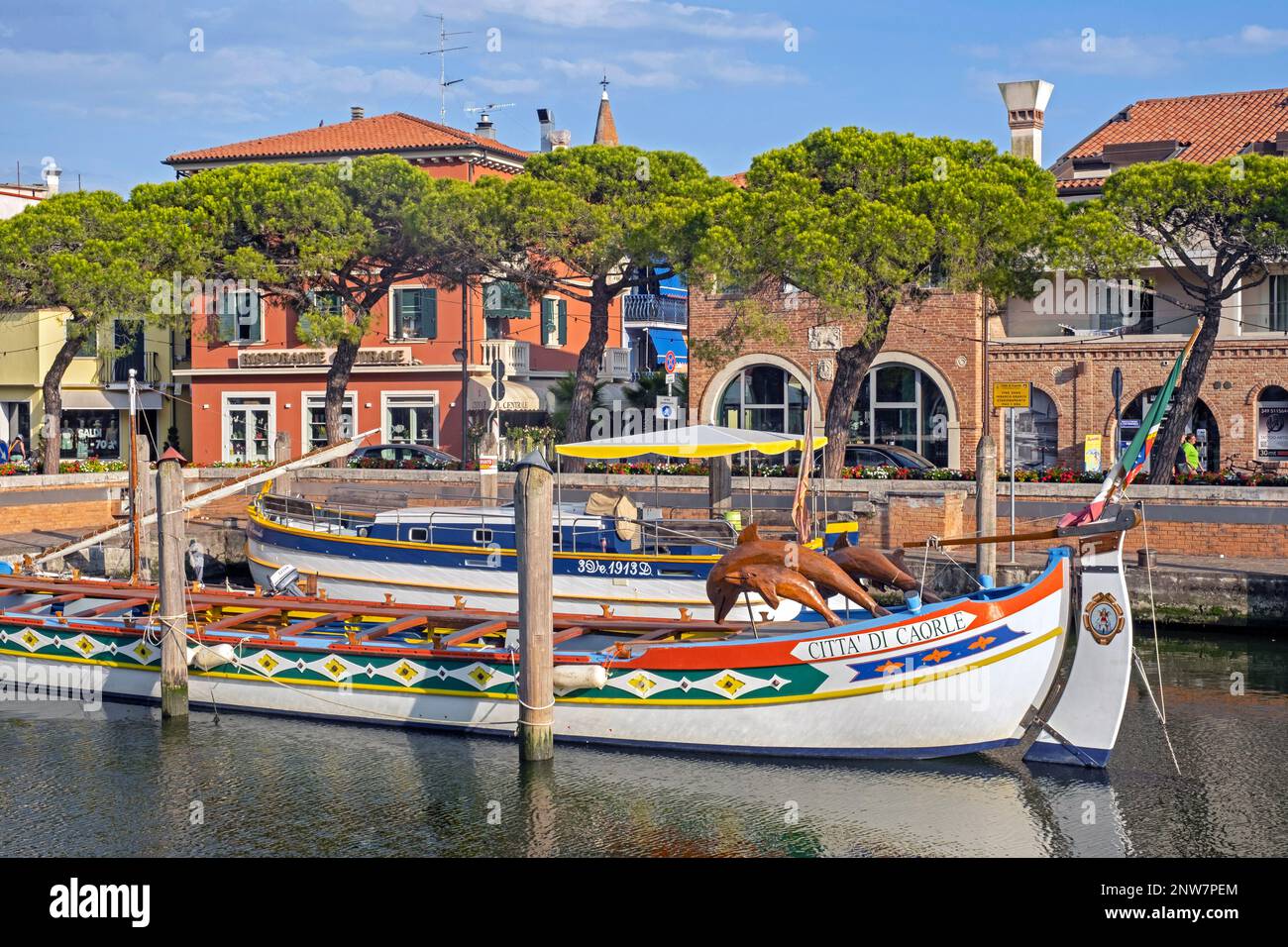 Bateau traditionnel en bois ancré dans le canal de la ville de Caorle, ville côtière de la ville métropolitaine de Venise, Vénétie, Italie du Nord Banque D'Images