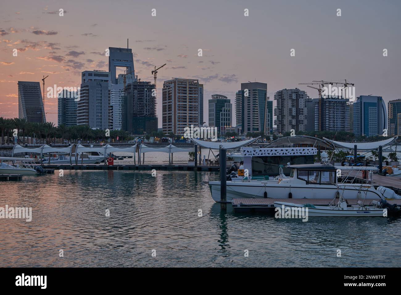 Lusail marina dans la ville de Lusail, Qatar coucher de soleil avec Yachts et bateaux avec drapeau du Qatar, horizon de Lusail et nuages dans le ciel en arrière-plan Banque D'Images