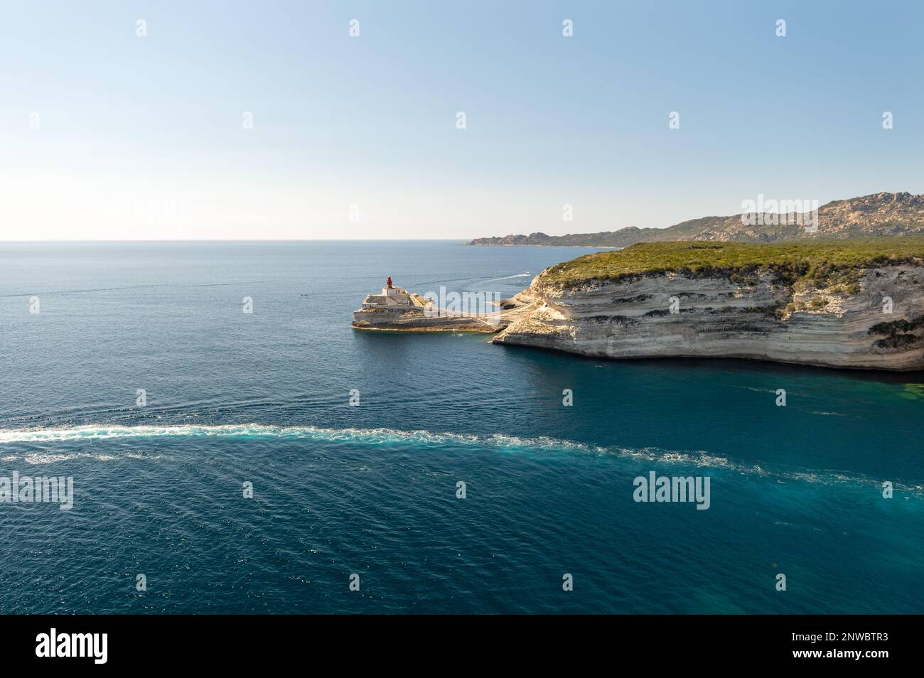 Vue sur le phare de la Madonetta depuis les fortifications de Bonifacio en Corse, mer bleue et falaises calcaires Banque D'Images