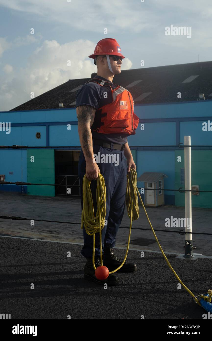 ÉTATS-UNIS Garde côtière Petty Officer 3rd classe Eziekial Miller, un controlman de dégâts affecté à la pierre de l'USCGC (WMSL 758), est prêt à lancer une ligne de charge à la Barbade le 23 janvier 2022. Stone est en cours de déploiement de plusieurs missions dans l'océan Atlantique Sud pour contrer les activités maritimes illicites et renforcer les relations de souveraineté maritime dans l'ensemble de la région. Banque D'Images