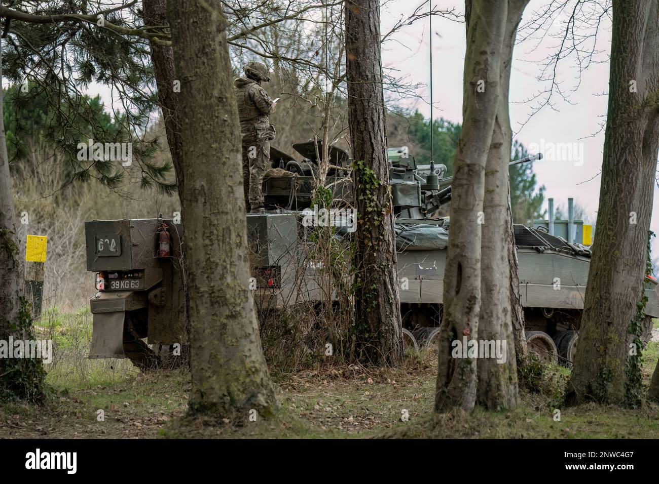 Le soldat se tient au-dessus d'un véhicule de combat du guerrier FV510 de l'armée britannique Banque D'Images