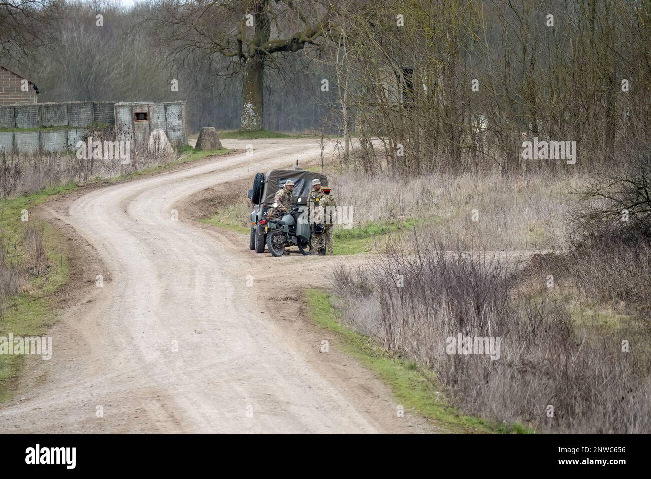 un pilote d'expédition de moto met à jour les soldats avec un véhicule utilitaire Banque D'Images