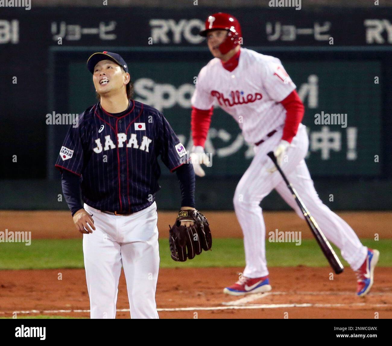 All Japan starter Daichi Osera watches the flight of a solo home-run hit by MLB All-Star designated hitter Rhys Hoskins, right, of the Philadelphia Phillies in the second inning of Game 4 at their All-Stars Series baseball at Mazda Zoom-Zoom Stadium in Hiroshima, western Japan, Tuesday, Nov. 13, 2018. (Kyodo News via AP) Banque D'Images