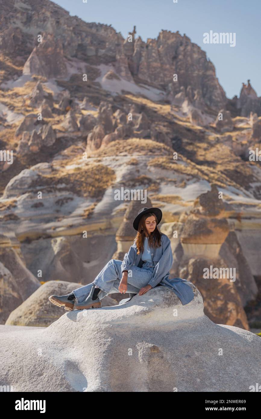 Une jeune fille sexy de voyageur est assise sur une montagne avec la toile de fond de la Cappadoce turque. Visitez la Turquie. Vue incroyable. Banque D'Images