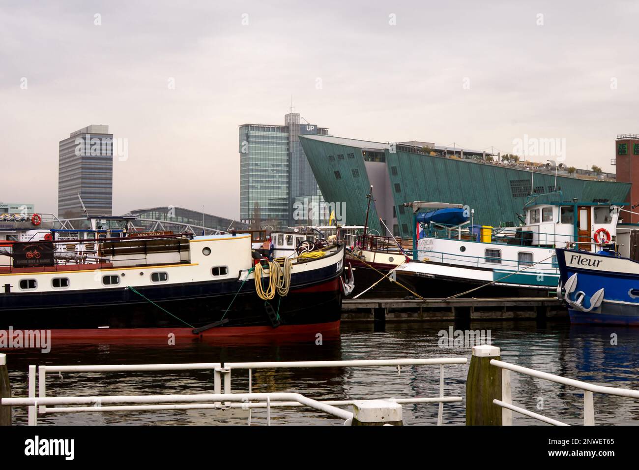 Musée des sciences NEMO à travers Oosterdock, Amsterdam, pays-Bas, avec des barges et des bateaux au premier plan Banque D'Images