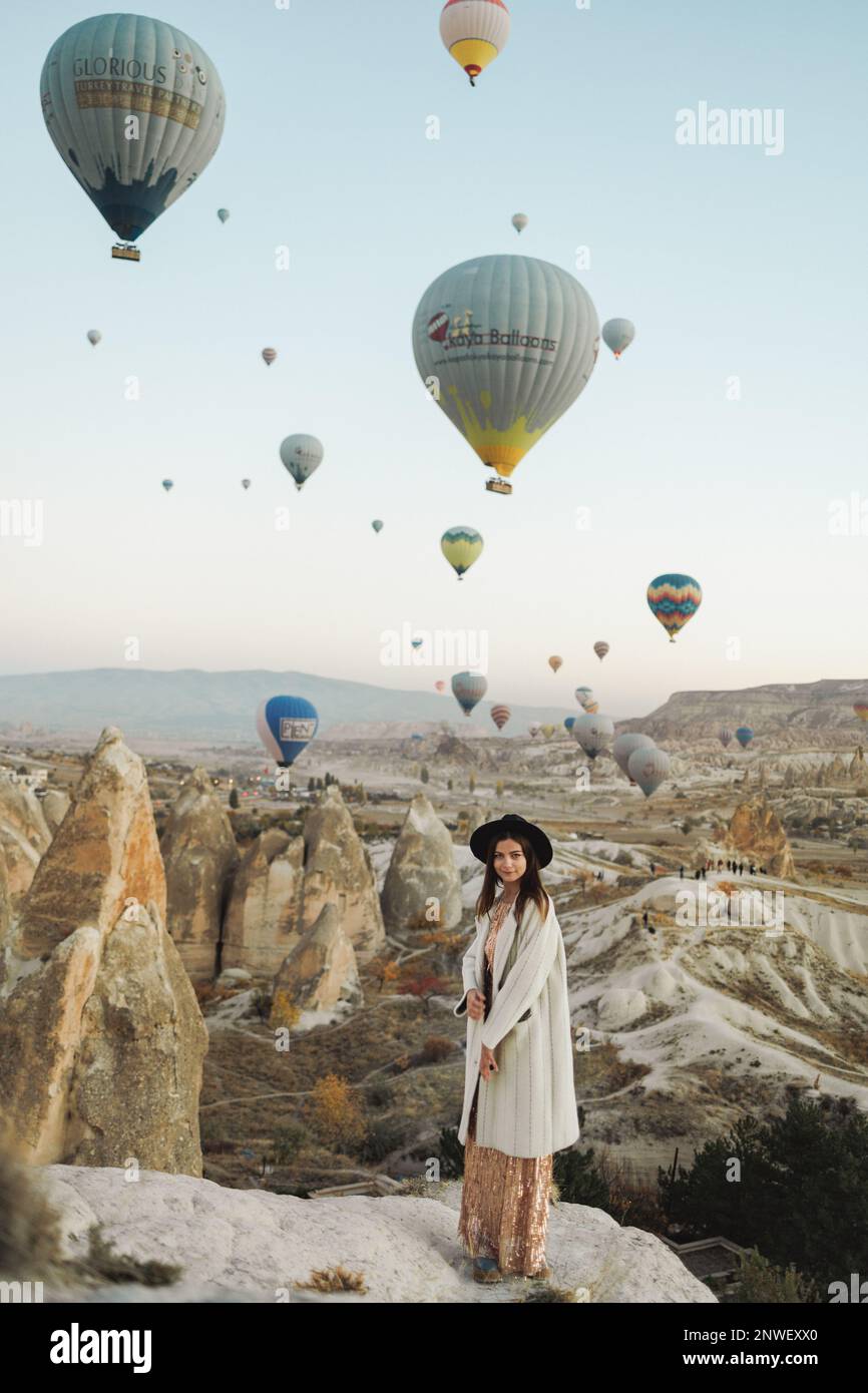 Une belle fille se tient et regarde des ballons en Cappadoce Banque D'Images
