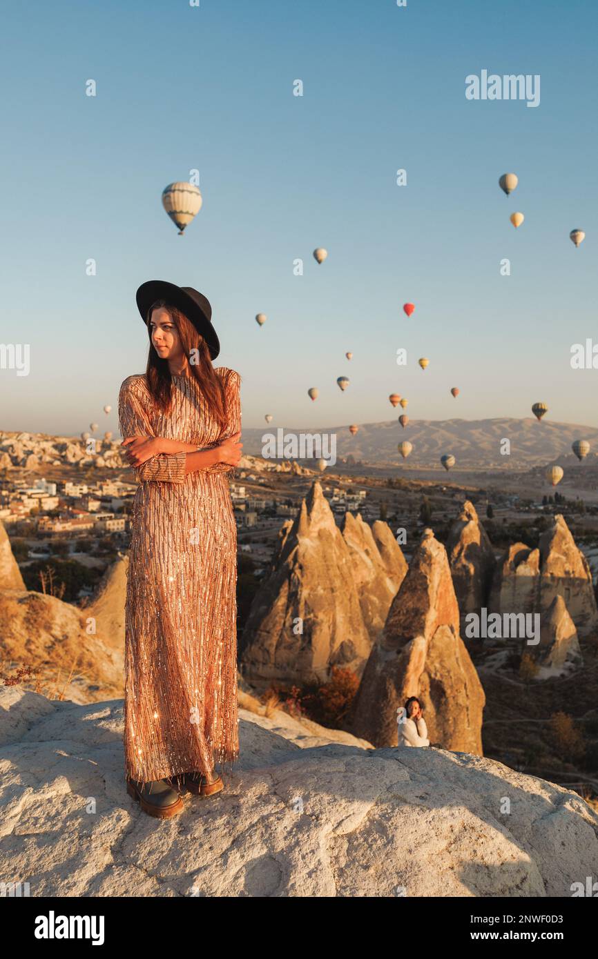 Une belle fille se tient et regarde des ballons en Cappadoce Banque D'Images