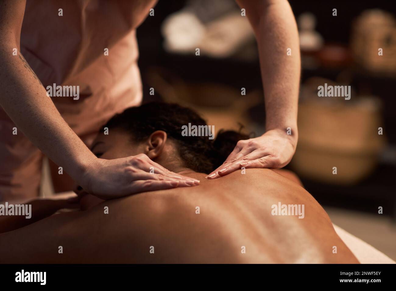 Masseuse massant le dos de la jeune femme avec des huiles naturelles Banque D'Images