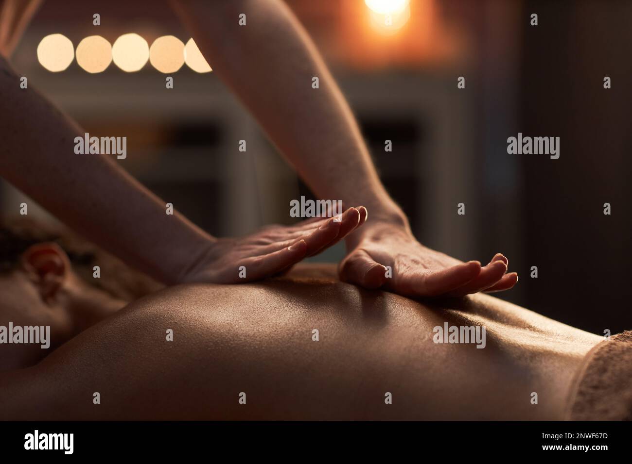 Masseuse appliquant une forte pression dans les muscles endoloris du client féminin Banque D'Images