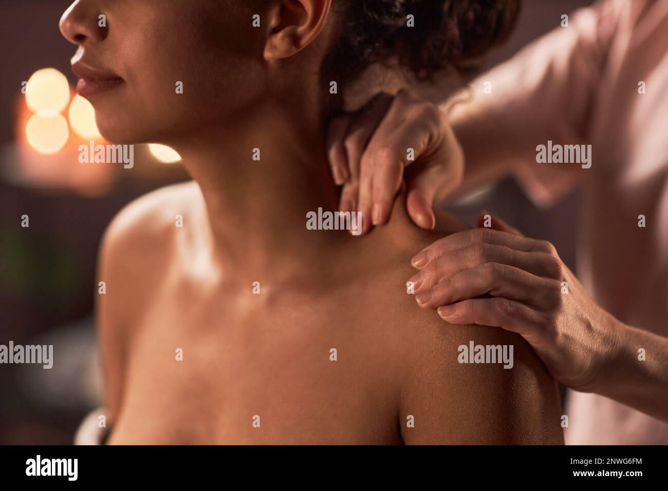 Massuese aidant la jeune femme à soulager la tension dans les muscles de l'épaule Banque D'Images