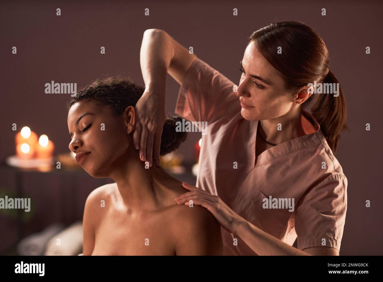 Masseuse massant le cou de la jeune femme qui prévient la tension et la douleur Banque D'Images