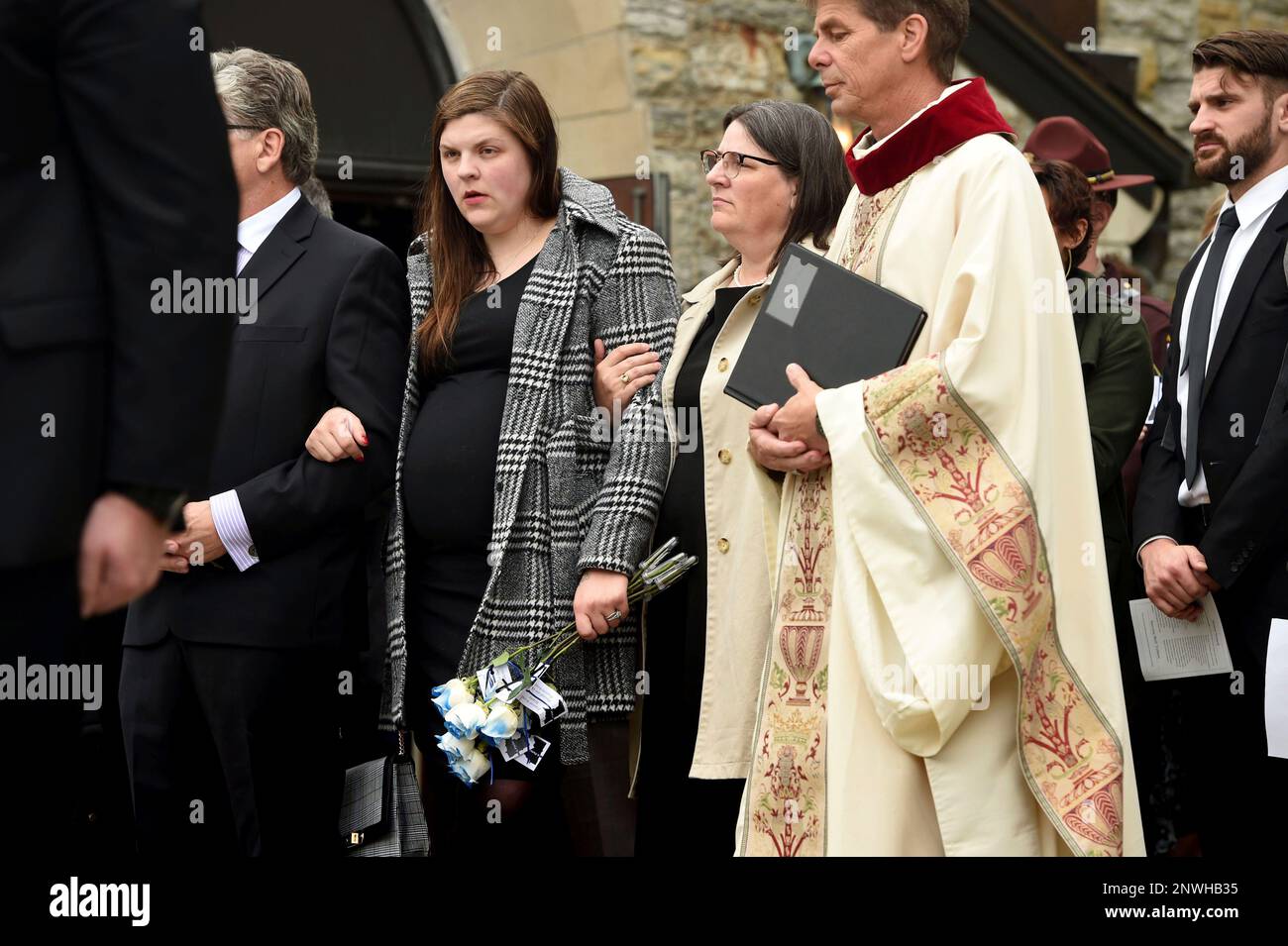 From left Mike Dean partially obscured Andrea Parise Nancy Dean and Most Rev. Martin Shanahan watch the Honor Guard perform their duties at the conclusion of funeral services for corrections officer J...