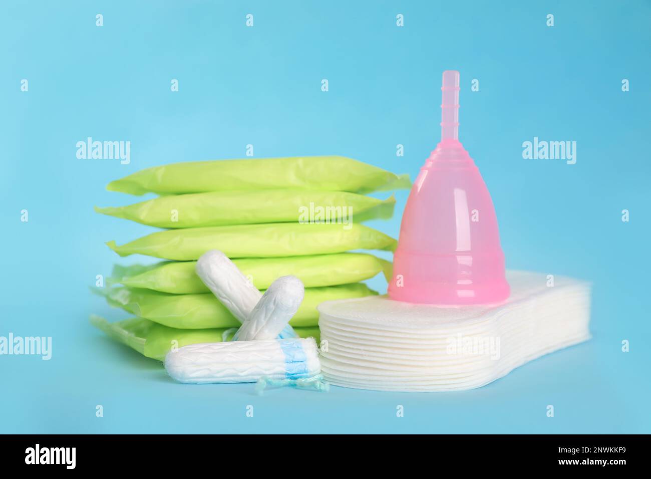 Coussinets et autres produits d'hygiène sur fond bleu clair Banque D'Images