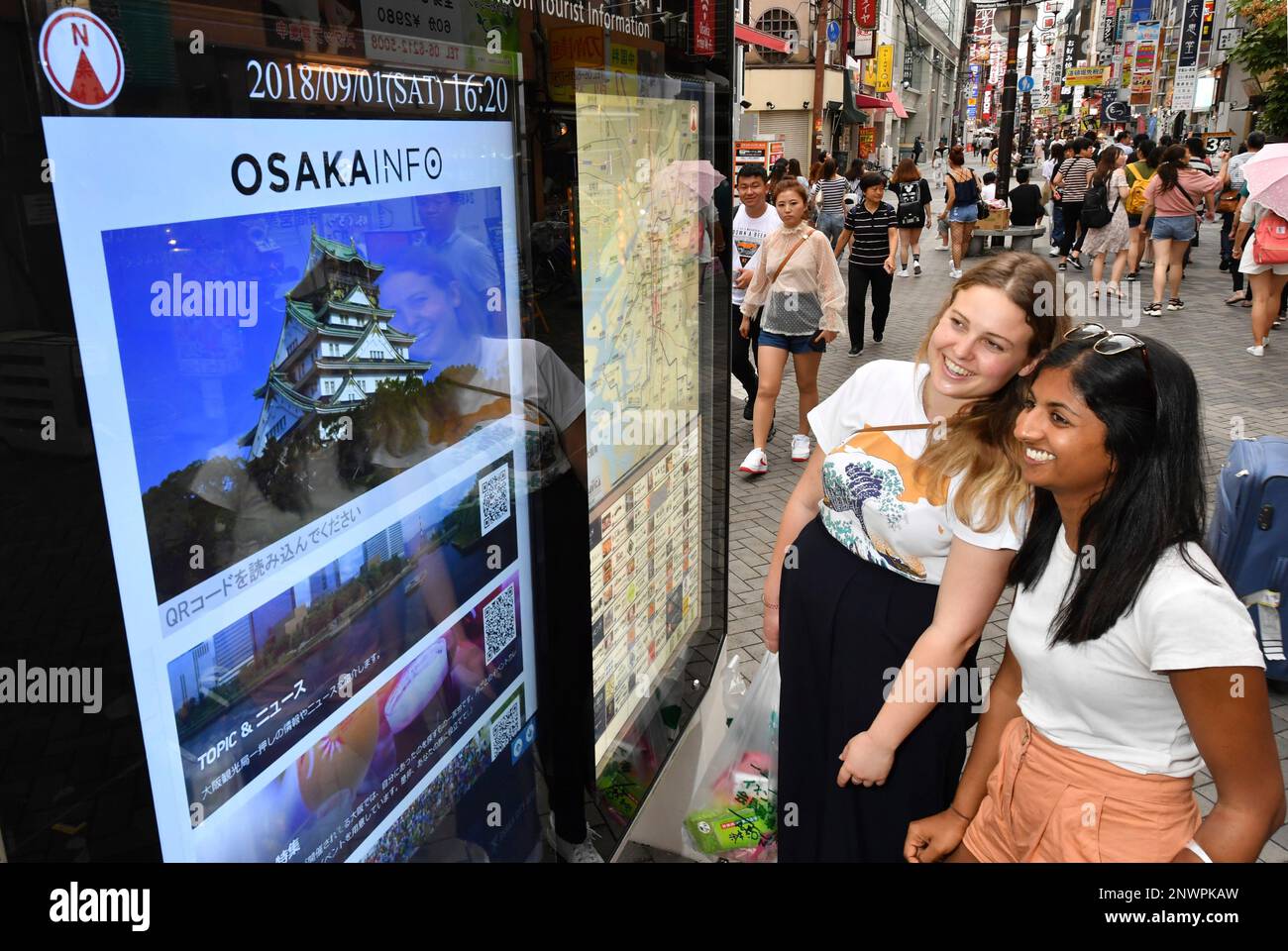Australian women watch an information board for tourists set by Osaka City in Osaka on Sep.1, 2018. The Economist announced the ranking of liveable cities in the world in August and Osaka was third, Tokyo was 8th. Osaka used to be 14th last year, however traffic convenience and the good public safety was evaluated.( The Yomiuri Shimbun via AP Images ) Banque D'Images