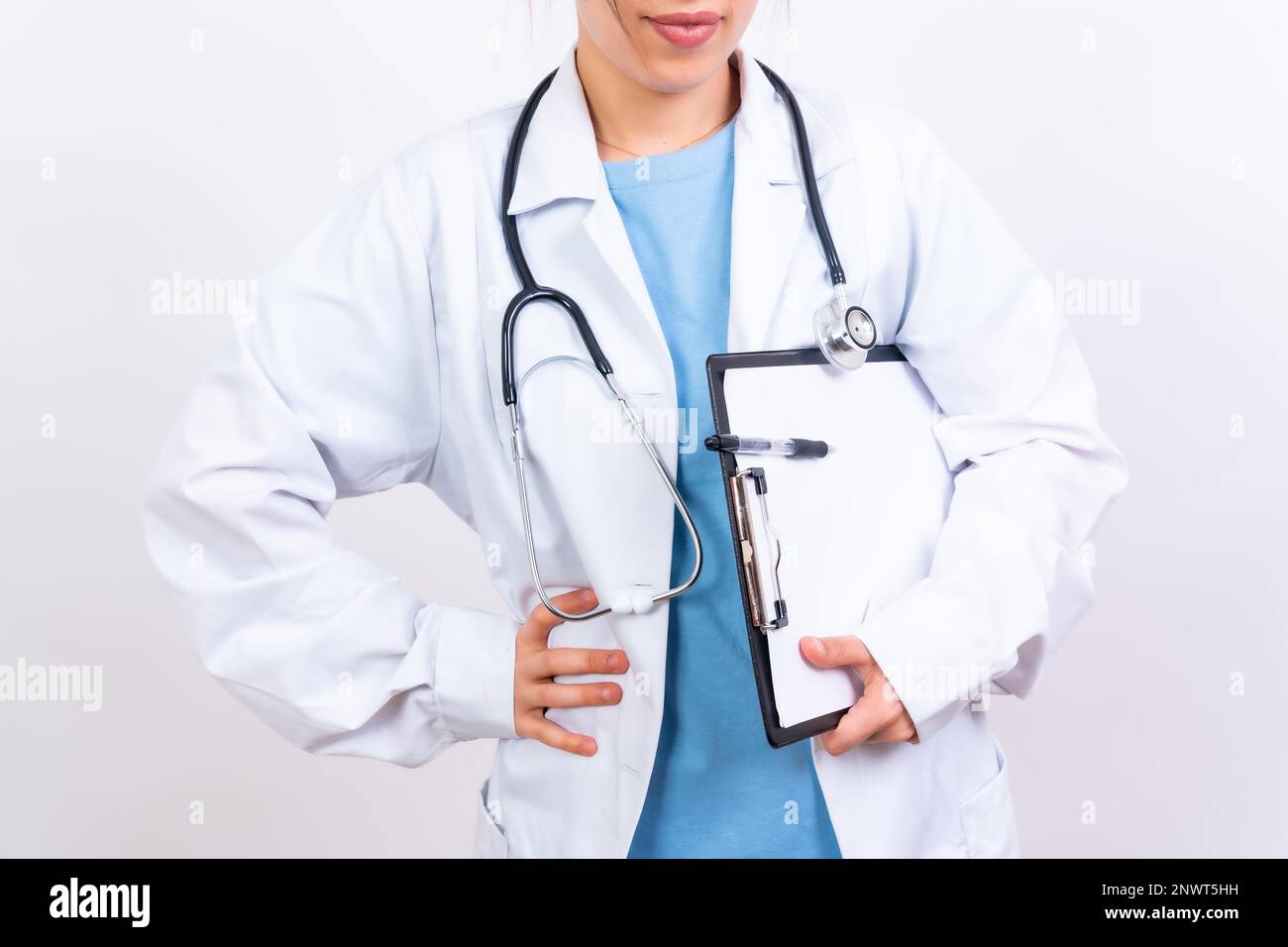 Heureuse belle femme médecin dans un manteau médical debout isolé sur blanc, concept de médecine Banque D'Images