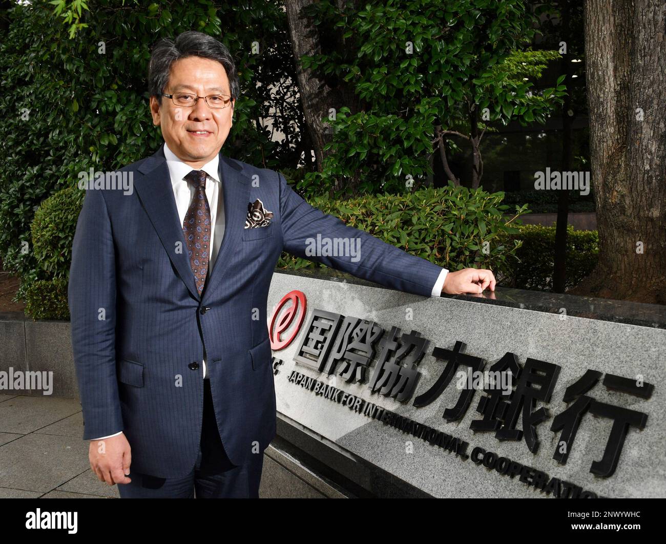 Tadashi Maeda, Governor of Japan Bank for International Cooperation (JBIC), poses for photo in front of a banner of the bank in Tokyo on July 12, 2018.( The Yomiuri Shimbun via AP Images ) Banque D'Images