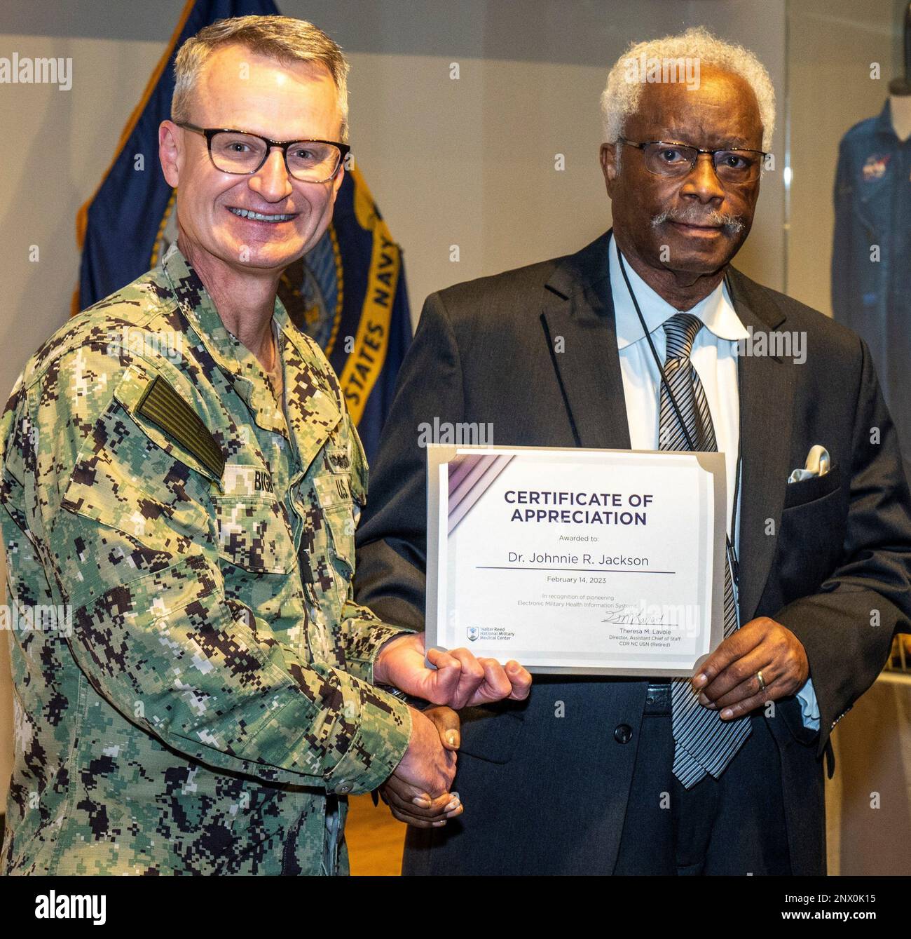 Le capitaine de la Marine Felix Bigby, directeur du centre médical militaire national Walter Reed, donne au lieutenant de l'Armée à la retraite le colonel Johnnie Jackson le certificat de reconnaissance pour avoir été un innovateur précoce dans l'établissement des dossiers de santé électroniques et de l'automatisation au sein du système de santé militaire (MHS) lors de la réunion mensuelle de la mairie du 14 février. (Photographies de Harvey A. Duze, Bureau des communications du commandement – WNMMC) Banque D'Images