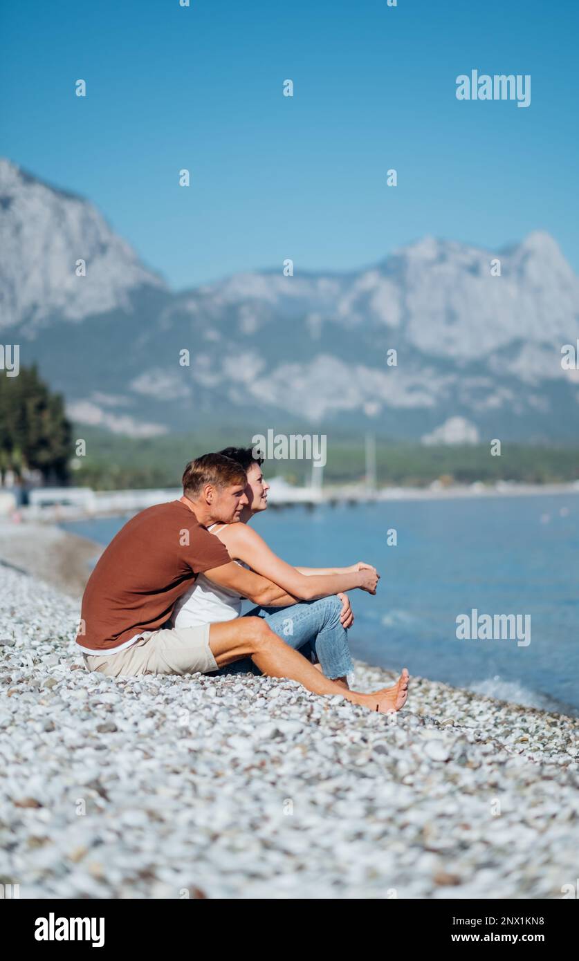 Portrait d'un couple aimant en train de profiter de la journée sur la plage avec des montagnes en arrière-plan Banque D'Images