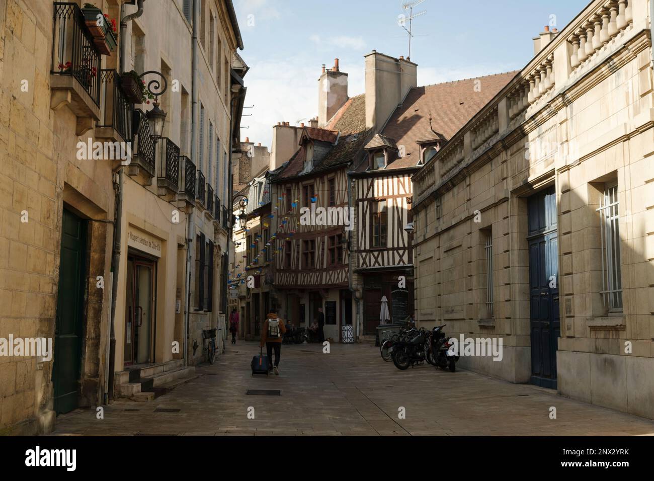 Voyageur solitaire dans la rue avec des bâtiments historiques typiques dans le centre de Dijon Banque D'Images