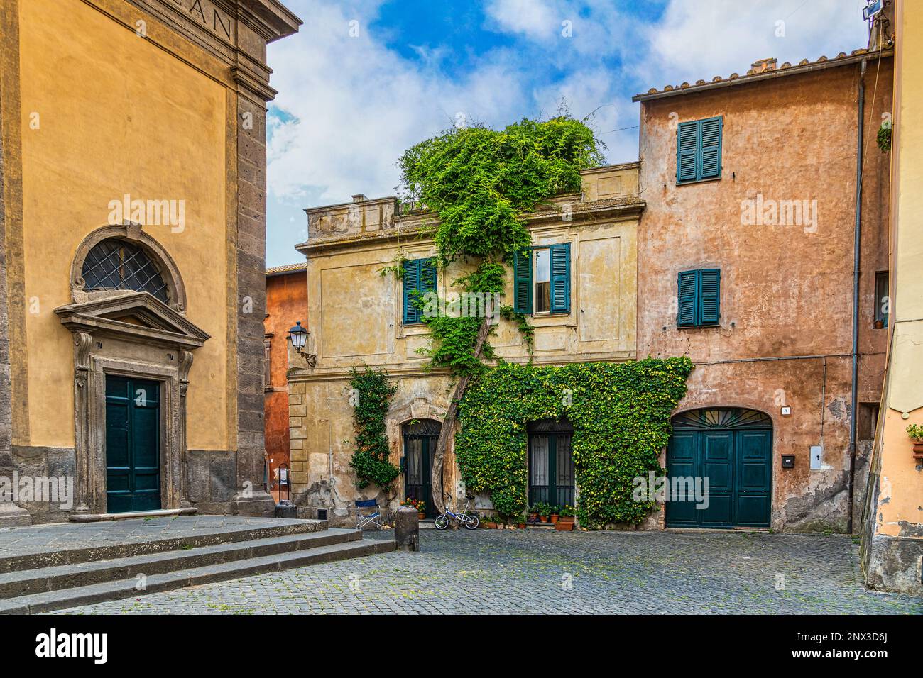 Aperçu de vieilles maisons colorées avec une porte et une porte vertes et une plante grimpante sur le mur. Tuscania, province de Viterbo, Latium, Italie, Europe Banque D'Images