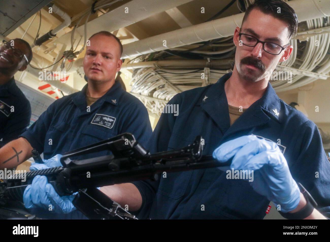 MER DE CHINE MÉRIDIONALE (2 février 2023) - opérateur d'équipement 3rd classe Kevin Epperly, affecté à l'unité de maître de plage (BMU) 1, effectue M4 opérations d'entretien de carabines à bord du navire de transport amphibie USS John P. Murtha (LPD 26), 2 février 2023. La carabine de service M4 est utilisée dans toute la flotte pour des mesures de protection de la force, et des exercices de tir direct sont nécessaires tous les six mois pour renforcer les compétences en matière de manipulation des armes, ce qui permet de maintenir la létalité des personnes qui regardent des tiers dans toute la Marine. Le groupe de préparation amphibie de l'île de Makin, composé du navire d'assaut amphibie USS Makin Island (LHD 8) et des quais de transport amphibie U Banque D'Images