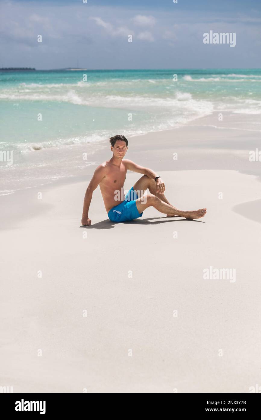 Un homme se détend sur Une belle plage aux Maldives. Banque D'Images