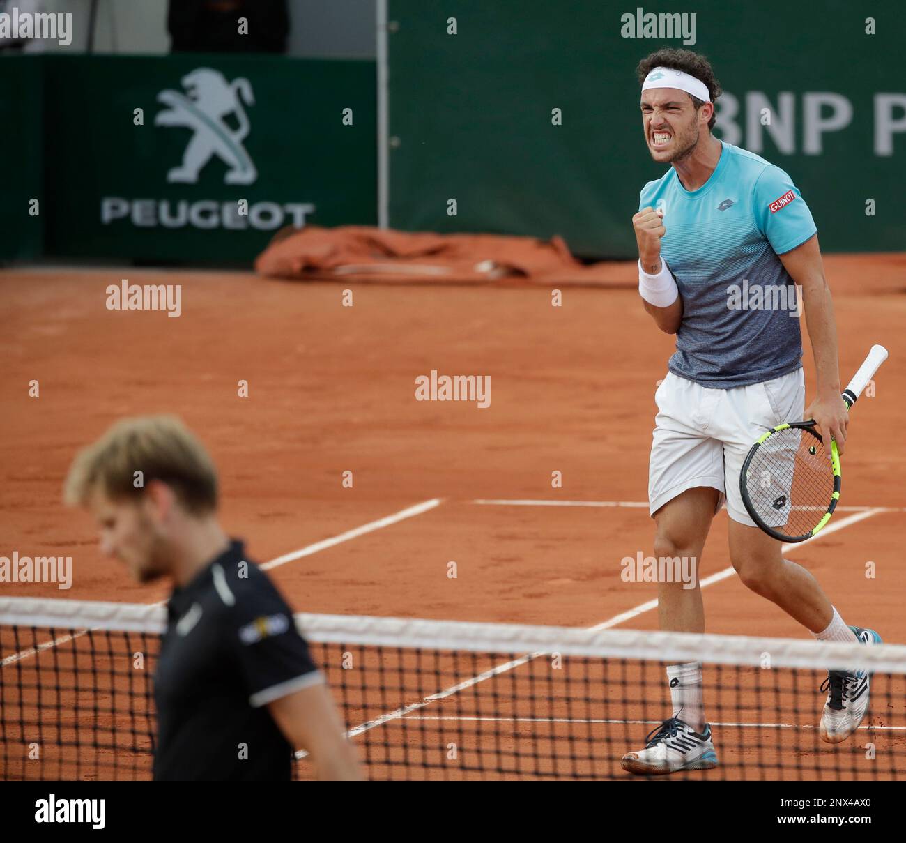 Italy's Marco Cecchinato, right, clenches his fist after scoring a point against Belgium's David Goffin, bottom left, during their fourth round match of the French Open tennis tournament at the Roland Garros stadium in Paris, France, Sunday, June 3, 2018. (AP Photo/Alessandra Tarantino) Banque D'Images