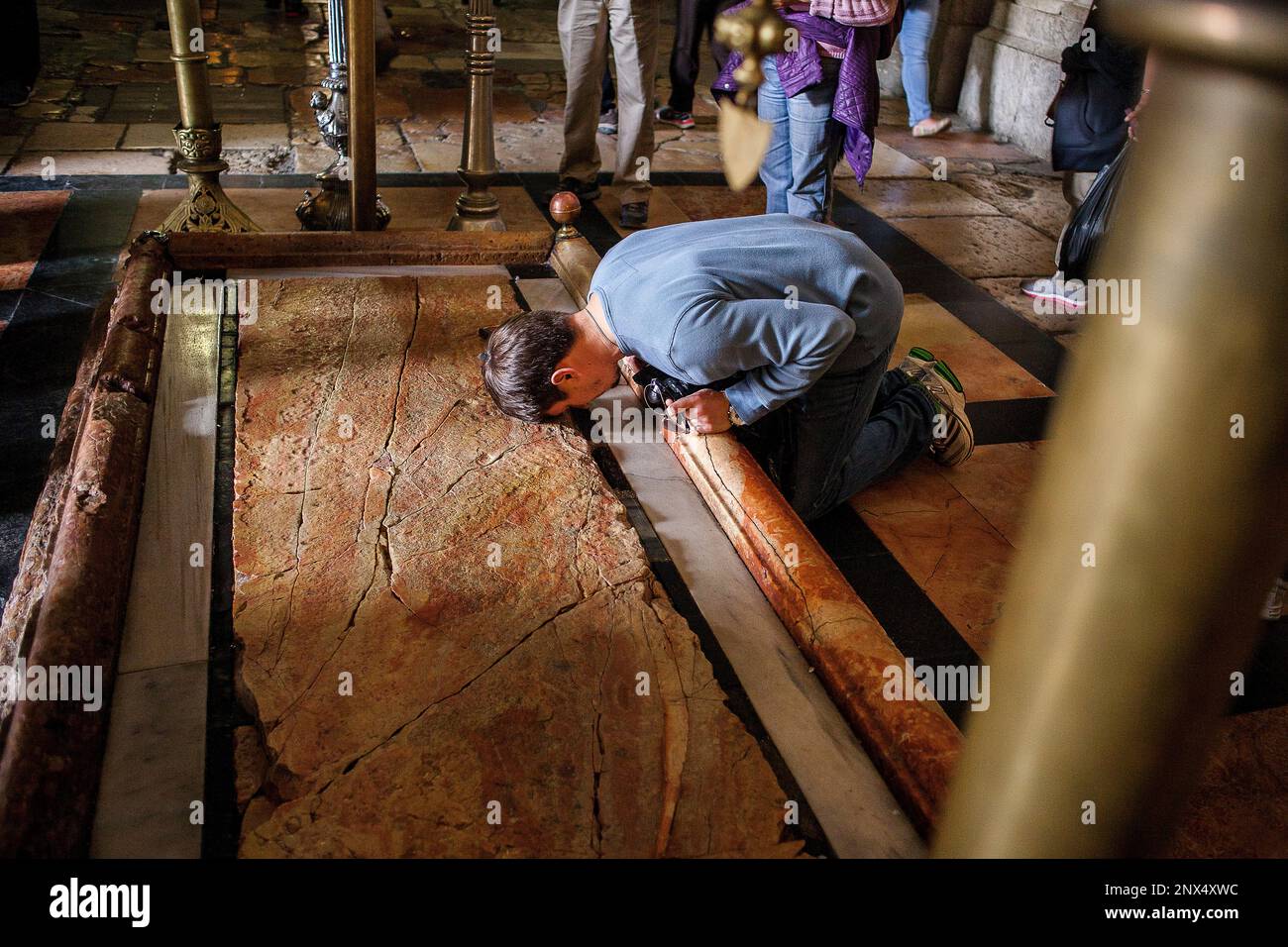 Homme qui prie,Pierre d'onction, l'église du Saint Sépulcre a également appelé l'église de la résurrection, quartier chrétien,Vieille Ville, Jérusalem, Israël. Banque D'Images