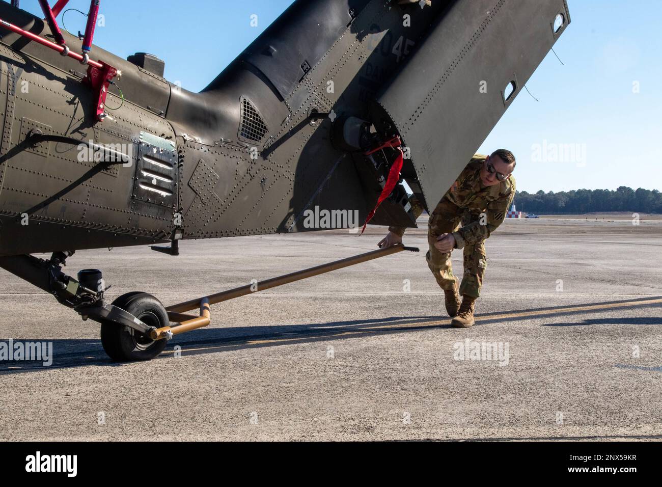 Un soldat de la division d'infanterie 3rd, une brigade de l'aviation de combat, 3rd, guide un UH-60 Blackhawk sur un C-17 Globemaster lors d'un entraînement de chargement aérien conjoint à l'aérodrome de l'armée de chasseurs, Géorgie, 10 janvier 2023. Les soldats ont travaillé avec des aviateurs des escadrons de transport aérien de 15th et 16th, à la base interarmées de Charleston, apprenant à charger et décharger deux BLACKHAWKS UH-60 sur le C-17 Globemaster. Banque D'Images