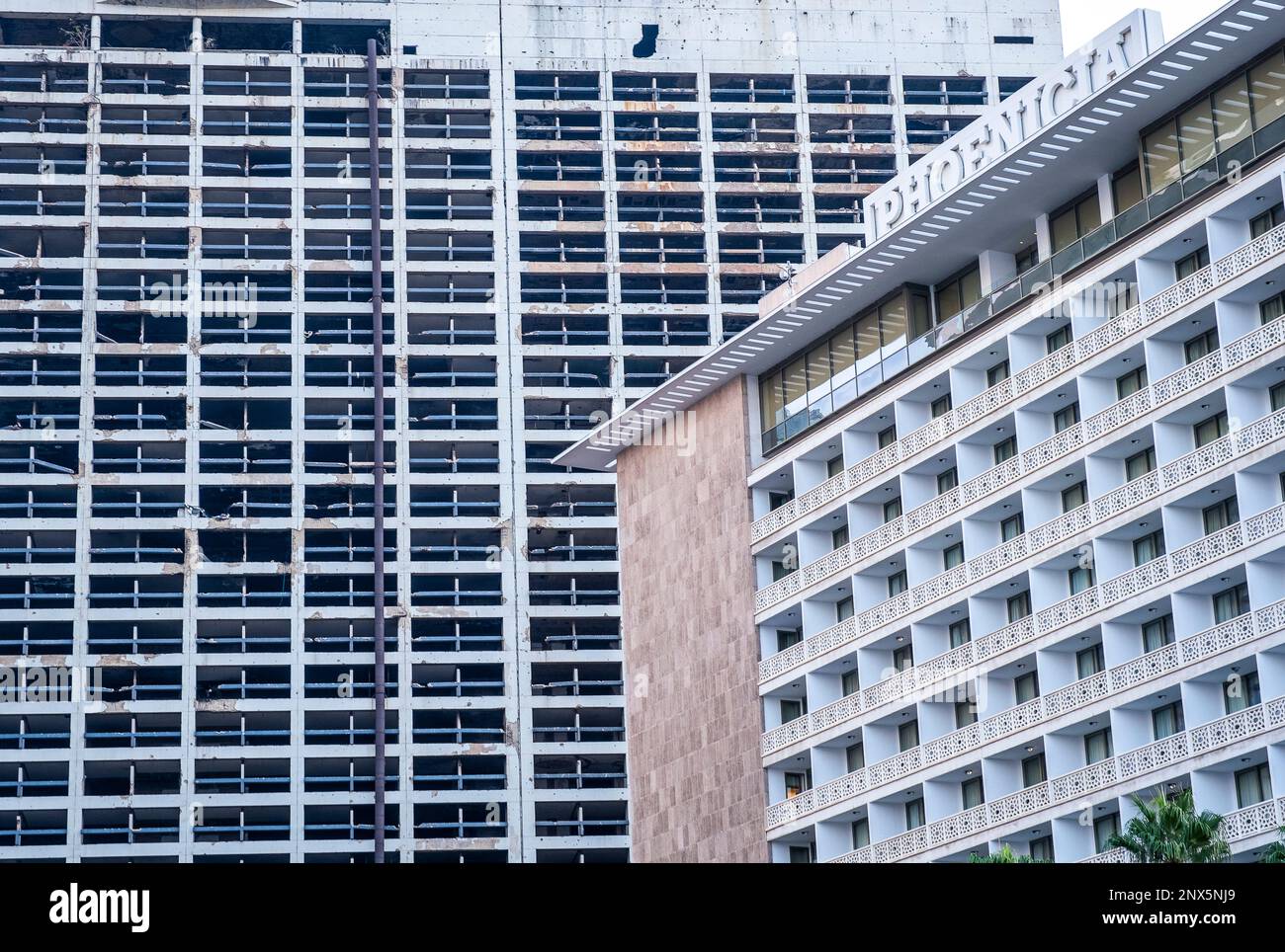 L'ancien Holiday Inn Hotel brisées par la guerre civile, à côté du nouvel Hôtel Phenicia, Beyrouth Banque D'Images