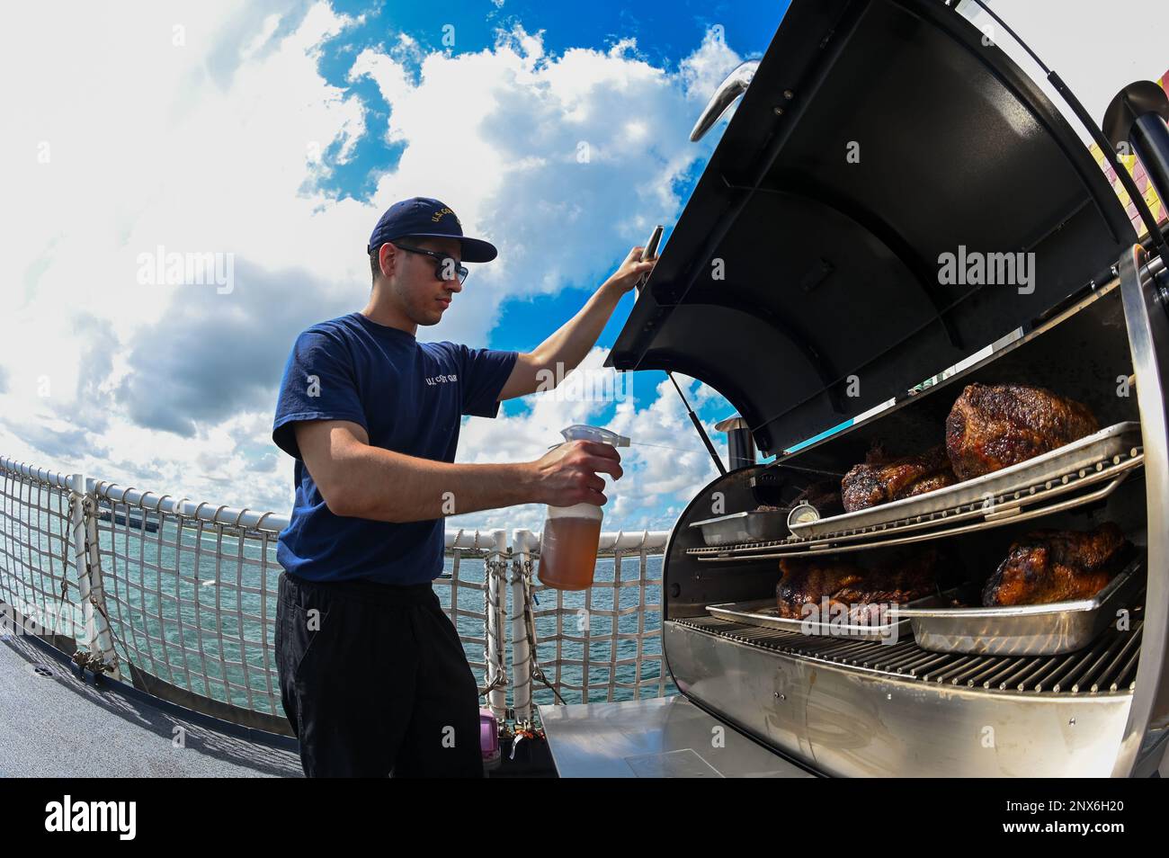 ÉTATS-UNIS Garde côtière Petty Officer 3rd classe Olvil Lasantaramos, un spécialiste culinaire affecté à la pierre USCGC (WMSL 758), prépare un dîner sur le pont de vol à Suape, Brésil, le 2 février 2023. Stone est en cours de déploiement de plusieurs missions dans l'océan Atlantique Sud pour contrer les activités maritimes illicites et renforcer les relations de souveraineté maritime dans l'ensemble de la région. Banque D'Images