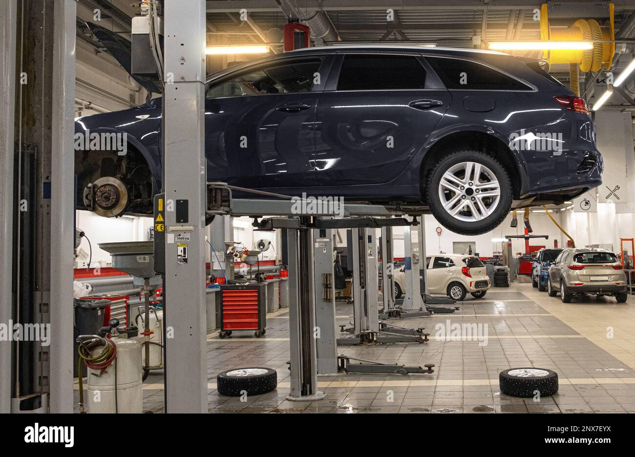 Voiture sur un ascenseur dans un centre d'entretien pour l'entretien préventif et les contrôles du système Banque D'Images