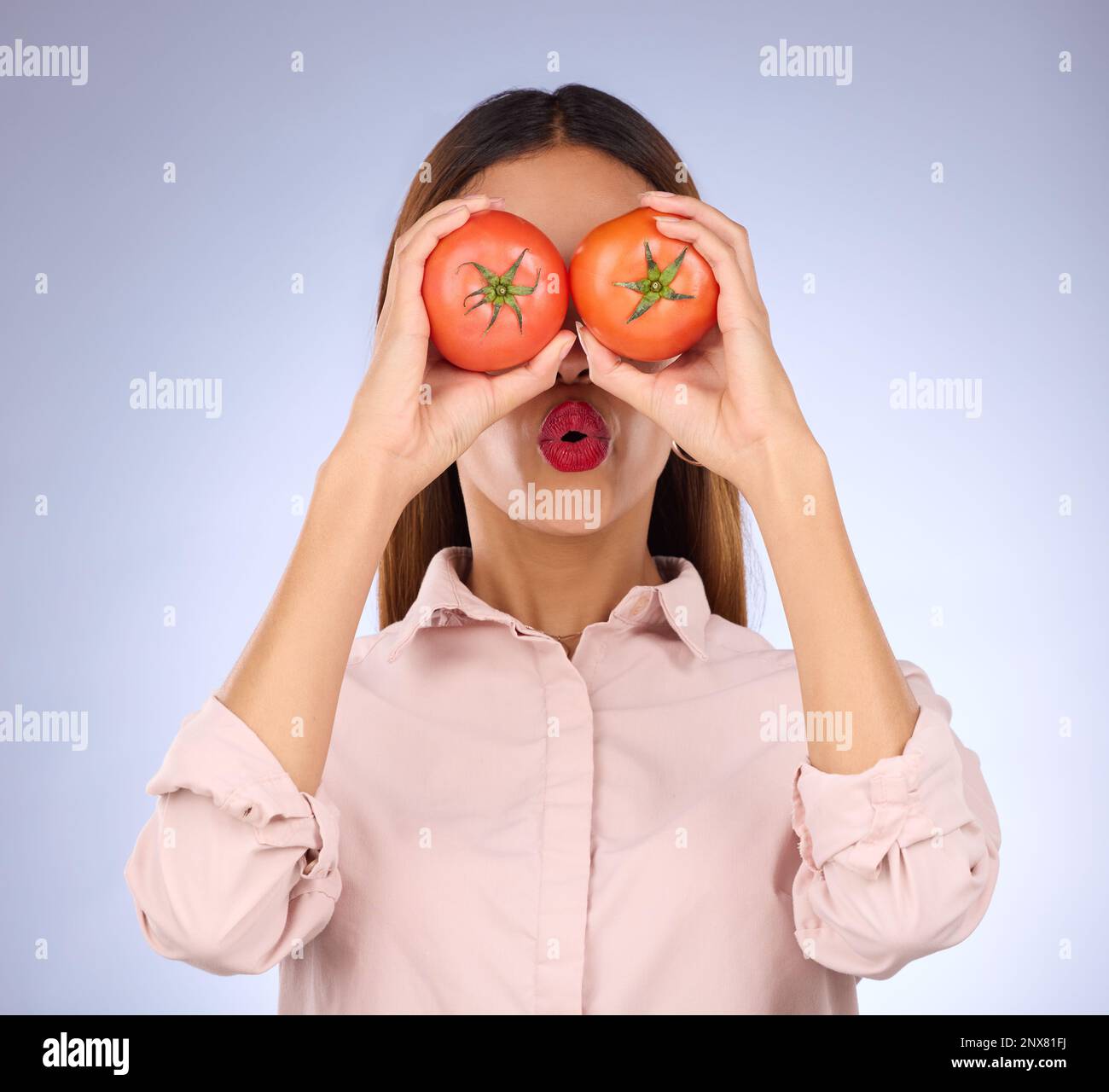 Femme, tomate et les yeux de couverture en studio pour la nourriture saine, le régime végétalien et les légumes dans les mains. Visage d'une personne modèle avec des légumes rouges pour la santé Banque D'Images