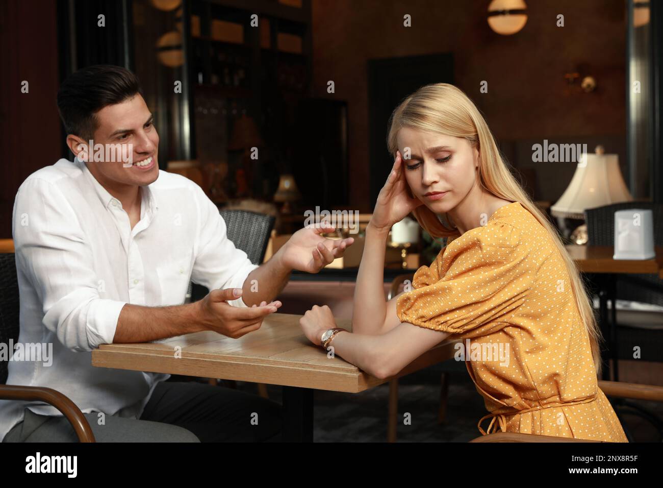 Jeune femme ayant une date ennuyeuse avec un homme de conversation dans un café Banque D'Images